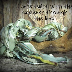 May include: A close-up of a decorative textile piece in shades of green, blue, and gold, with the text "Loose twist with the raw ends through the loop." The textile is arranged on a wooden surface.