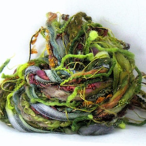 May include: A tangle of colorful yarn and ribbon in shades of green, brown, purple, and gold. The yarn is arranged in a loose, organic shape, creating a visually interesting and textured piece.