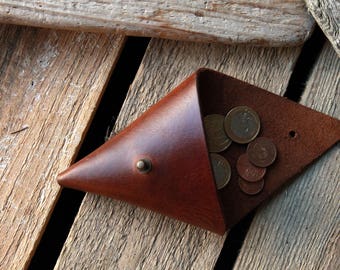 May include: A brown leather coin purse with a flap closure. The purse is open and filled with coins.