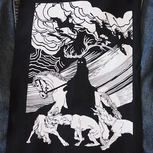 May include: A denim jacket with a large black patch on the back. The patch features a black and white illustration of a figure with antlers riding a horse, surrounded by wolves and other figures.
