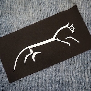 Könnte beinhalten: Schwarzer Bügel-Patch mit einer weißen Umrandung eines galoppierenden Pferdes. Das Pferd blickt nach rechts und hat eine lange, fließende Mähne.