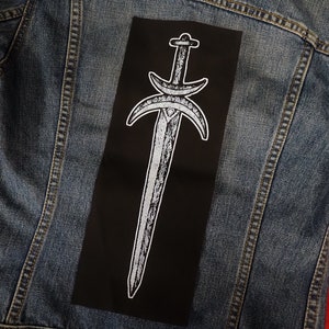 May include: Black fabric patch with a white embroidered design of a sword with two crescent moons on either side.