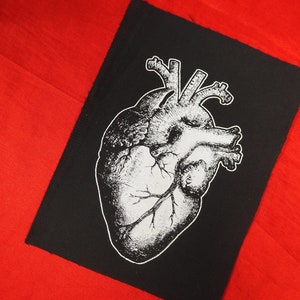 May include: Black and white anatomical heart illustration on a black fabric patch. The heart is detailed with veins and arteries.