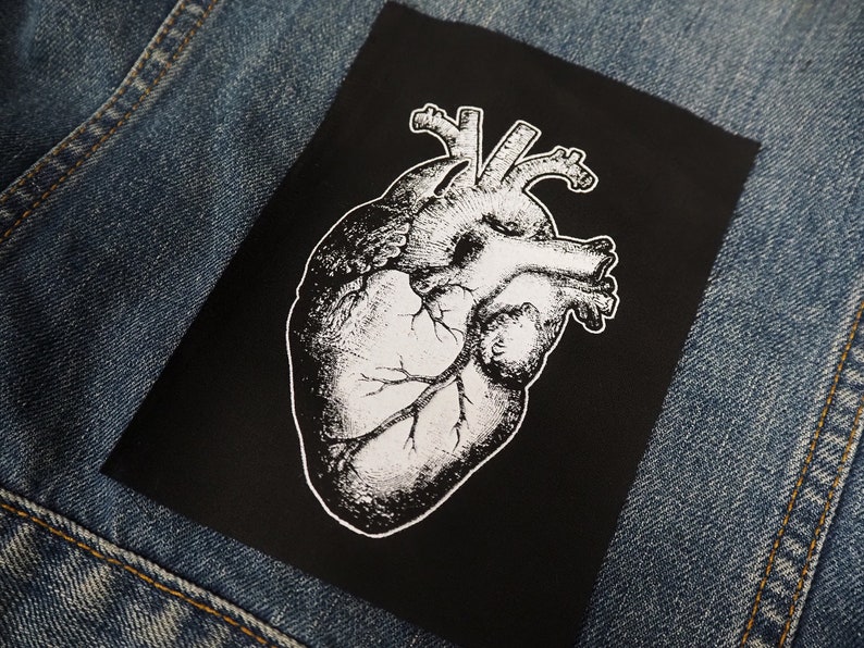 May include: Black and white anatomical heart illustration on a black fabric patch.