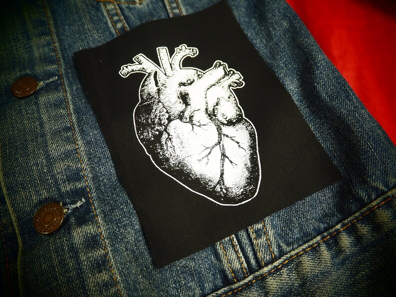 May include: A black iron-on patch with a white anatomical heart illustration.