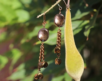 May include: A pair of long, dangling earrings with a copper chain and a round, iridescent copper bead at the top of each earring.