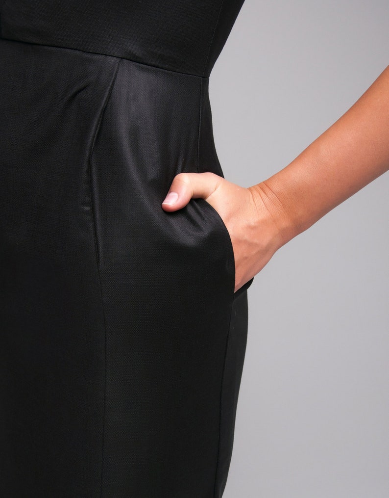 May include: A black dress with a fitted silhouette and a single pocket on the side.
