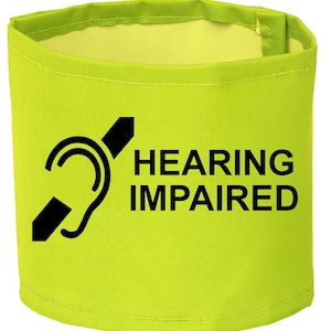 May include: A bright yellow fabric armband with a black symbol of a crossed-out ear and the text "HEARING IMPAIRED".