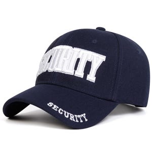 Könnte beinhalten: Eine marineblaue Baseballkappe mit dem Wort SECURITY, das in großen weißen Blockbuchstaben auf die Vorderseite gestickt ist, sowie dem Wort SECURITY in kleineren weißen Buchstaben auf der linken Seite des gebogenen Schirms.
