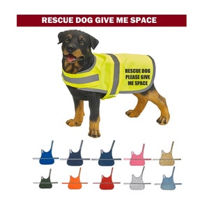 Puede incluir: Un perro Rottweiler con un chaleco amarillo brillante con rayas reflectantes. El chaleco tiene el texto "RESCUE DOG PLEASE GIVE ME SPACE". Debajo hay varias opciones de color de chaleco, incluyendo azul, rosa y verde.