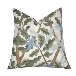 Peut inclure: Coussin décoratif carré avec un motif botanique. Le fond crème est orné de branches d'arbres brunes, de feuilles vertes et de fleurs bleu clair. Idéal pour la décoration intérieure.