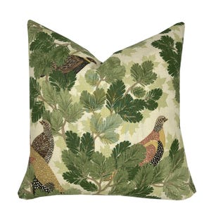 May include: A green and cream throw pillow with a repeating pattern of stylised pine branches and birds. The birds are brown, black and red with yellow accents.