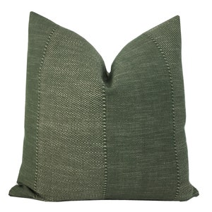 May include: A green throw pillow with a textured woven fabric. The pillow has a subtle white pattern throughout the fabric.