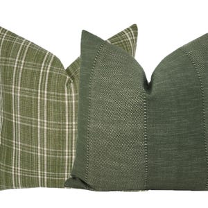 May include: Two green throw pillows, one with a plaid pattern and the other with a textured weave.