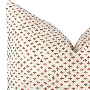 Peut inclure: Un oreiller blanc avec un motif de feuilles rouges. L'oreiller est fait d'un tissu doux et texturé.