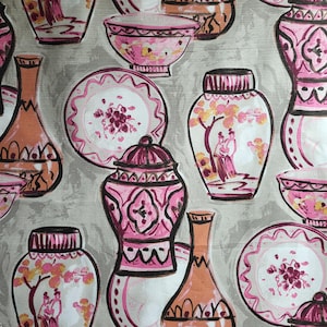 May include: A repeating pattern of pink and orange decorative vases, bowls, and plates on a gray background. The vases and bowls have black outlines and are decorated with floral and geometric designs. The plates have scalloped edges and floral centerpieces.