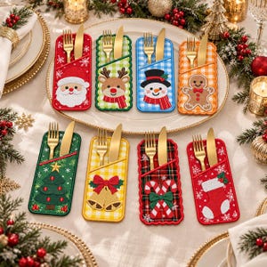 May include: Eight rectangular fabric cutlery holders featuring embroidered Christmas designs including Santa, a reindeer, a snowman, a gingerbread man, a tree, bells, candy canes, and a stocking, each holding a gold fork and knife.