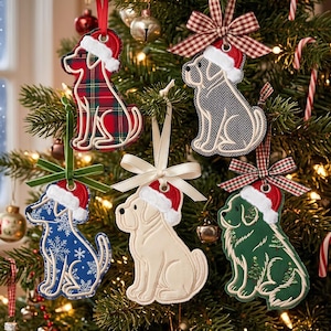 May include: Five fabric dog ornaments hanging on a Christmas tree. Each dog wears a white-trimmed red Santa hat. The dogs feature various patterns including red plaid, grey herringbone, blue with snowflakes, solid cream, and dark green with pine trees.