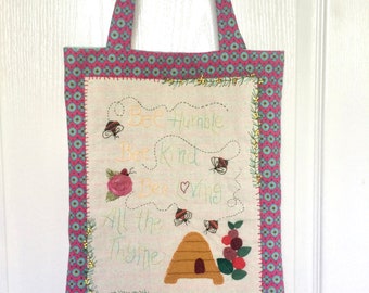 Tote bag with embroidered flowers and bees fabric.