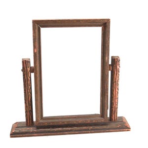 May include: A rectangular wooden swivel mirror frame with a dark brown finish. The frame is supported by two vertical posts featuring carved patterns, mounted on a rectangular base. The structure allows the central frame to rotate.