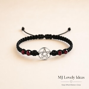 May include: A black macrame cord bracelet featuring a central silver-toned pentagram charm flanked by two dark red faceted beads on each side. The bracelet includes adjustable pull strings at the back. The text MJ Lovely Ideas is visible.