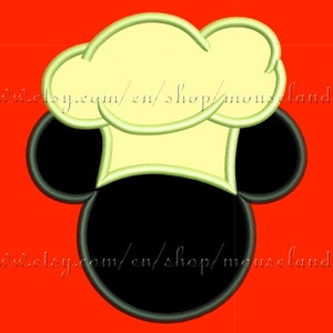 Könnte beinhalten: Ein Stickmuster mit der schwarzen Silhouette eines Mäusekopfes mit runden Ohren, gekrönt von einer blassgelben Kochmütze mit hellgrünen Nähten. Der Text www.etsy.com/en/shop/mouselandia ist auf dem Bild deutlich zu erkennen.
