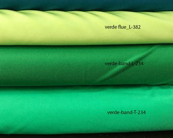 May include: Four rolls of fabric in different shades of green. The top roll is teal blue, the second roll is light green, the third roll is dark green, and the bottom roll is a brighter green. Each roll has a label with the name and code of the fabric.