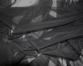 May include: Black sheer tulle fabric with a soft, delicate texture. The fabric is folded and draped, showcasing its transparency and drape.