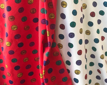 May include: Two fabric swatches with a repeating pattern of colorful circles. The fabric on the left is red with dark blue, yellow, and green circles. The fabric on the right is white with dark blue, yellow, and green circles.