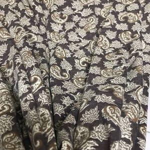 May include: Brown fabric with a paisley and leaf pattern in beige and brown.