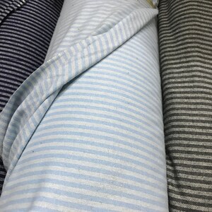 May include: Three rolls of striped fabric. One roll is navy blue and white, one is light blue and white, and one is gray and white.