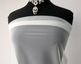 May include: White sheer fabric draped over a black mannequin. The fabric is very thin and translucent.