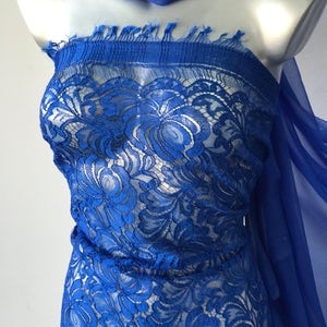 May include: Royal blue lace fabric with a floral pattern. The lace is delicate and sheer, and it would be perfect for a variety of projects, such as dresses, tops, and skirts.