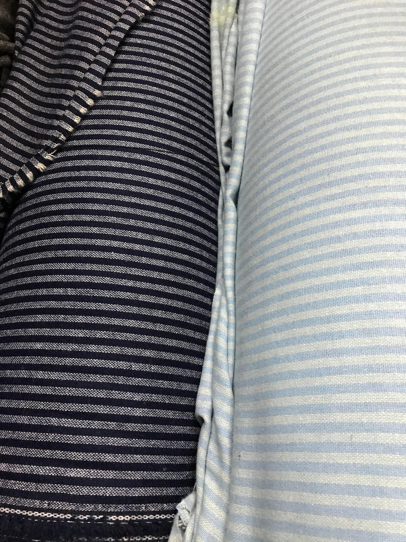 May include: Two rolls of striped fabric, one navy blue and white, and the other light blue and white.