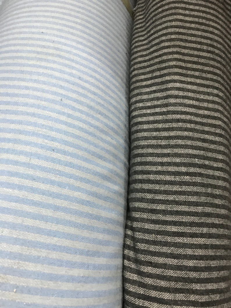 May include: Two rolls of striped fabric, one light blue and white, the other dark gray and white.