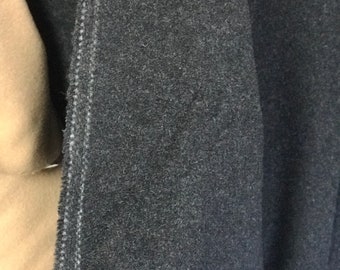 May include: Close-up of a dark gray fabric with a white seam running down the side.