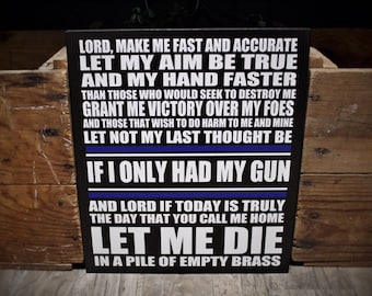 May include: Black rectangular sign with white text and a blue stripe. The sign features a prayer about speed, accuracy, and victory, ending with the phrase "If I Only Had My Gun" and "Let Me Die in a Pile of Empty Brass."