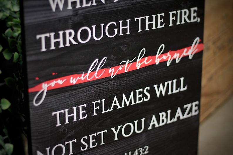 Puede incluir: Letrero de madera negro con texto blanco: "A TRAV&Eacute;S DEL FUEGO, no te quemar&aacute;s, LAS LLAMAS NO TE ENCENDER&Aacute;N". Las palabras "no te quemar&aacute;s" est&aacute;n tachadas con una l&iacute;nea roja. Art&iacute;culo decorativo.