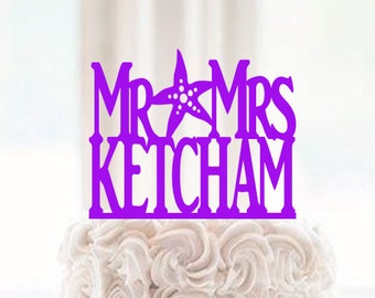 May include: A three-tiered white wedding cake with a purple topper that reads "Mr & Mrs Ketcham". The cake has a textured design on the top and bottom tiers, and a quilted pattern on the middle tier.