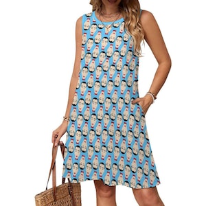 May include: Sleeveless blue dress with a repeating pattern of stylized faces. Each face has a black mustache, black hair, and a red bow tie. The dress has a scoop neckline and two pockets.