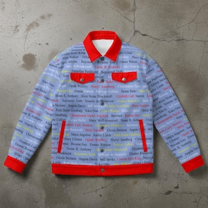 May include: A light blue denim jacket with a red collar, cuffs, and pocket trim. The jacket is covered in the names of influential women. Features two front pockets and red snap closures.