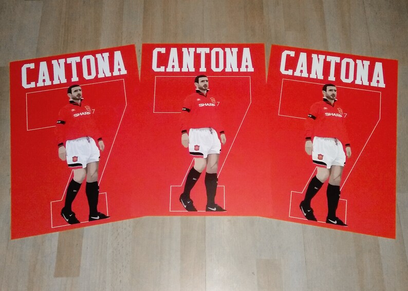 May include: Three red posters featuring a soccer player in a red jersey with the name "CANTONA" above and the number "7" on the jersey. The player is wearing white shorts and black socks and shoes.