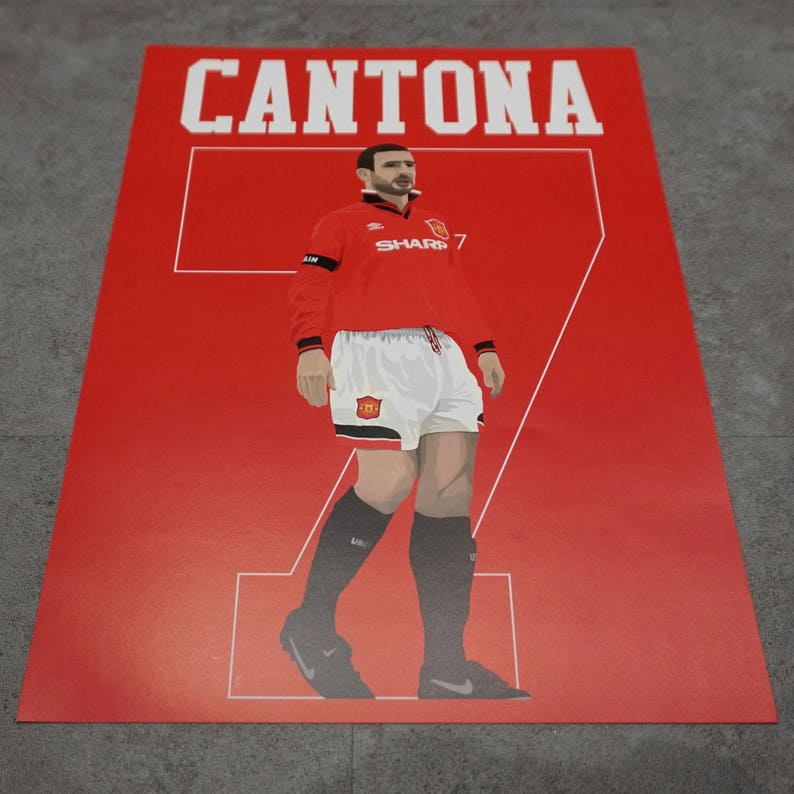 May include: A red poster featuring a stylized illustration of a soccer player in a red jersey with the name "CANTONA" above. The player wears white shorts and black socks, with the number "7" prominently displayed.