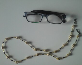 cord necklace wears glasses with pearl beads