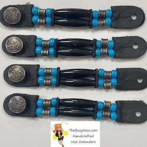 May include: Four black leather vest extenders with silver-toned buttons and decorative beads. Each extender features black cylindrical beads, turquoise beads, and silver-toned metal accents. The extenders are handcrafted.