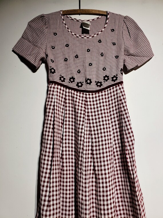 with decrotive watering pot An adorable little girl grape blue vintage gingham dress Free Shipping and a flower pot of daisy flowers.