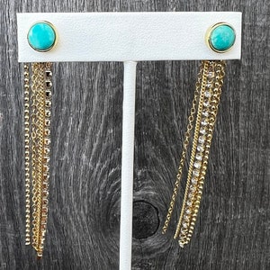 May include: A pair of turquoise stone earrings with gold chain and bead drop accents.