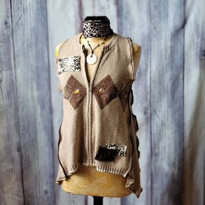 May include: A tan, sleeveless knitted vest with a full zip, brown diamond patterns, and decorative patches. The vest is displayed on a mannequin and accessorized with a patterned choker and a pendant necklace.