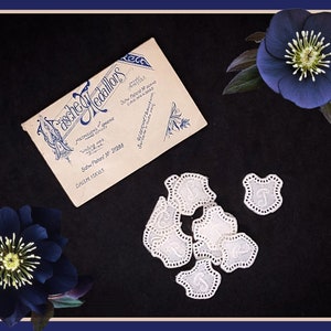 May include: A vintage business card for "Tasche Medallions" with the text "Medallions made in Germany" and "Sold Patent Nr 27288" on a black background with white lace doilies and two dark blue flowers.