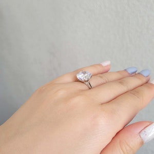 May include: A silver ring with a large, clear, round-cut gemstone.